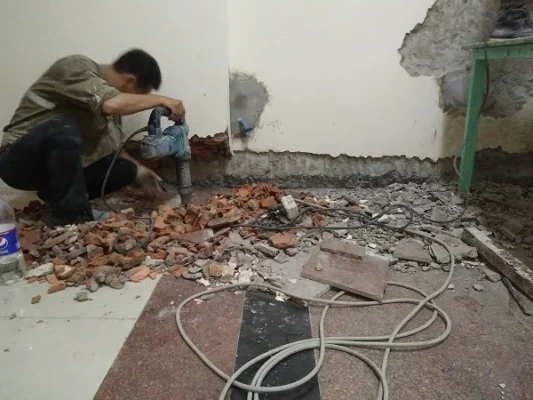 Đục bỏ lớp vữa yếu tại chân tường trước khi chống thấm