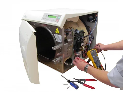 Technician inspecting and repairing an autoclave sterilizer