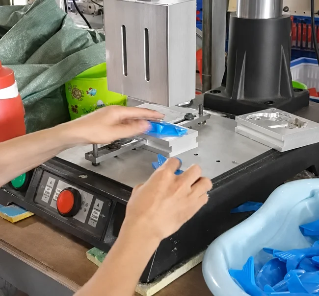 Placing plastic toy components into the ultrasonic welding fixture