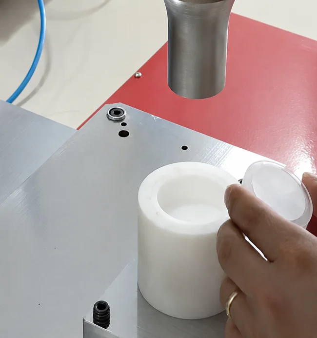 Placing the water filter cartridge into the ultrasonic welding fixture