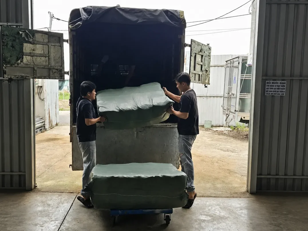 Nhân viên đưa kiện túi hột xoài lên xe giao hàng